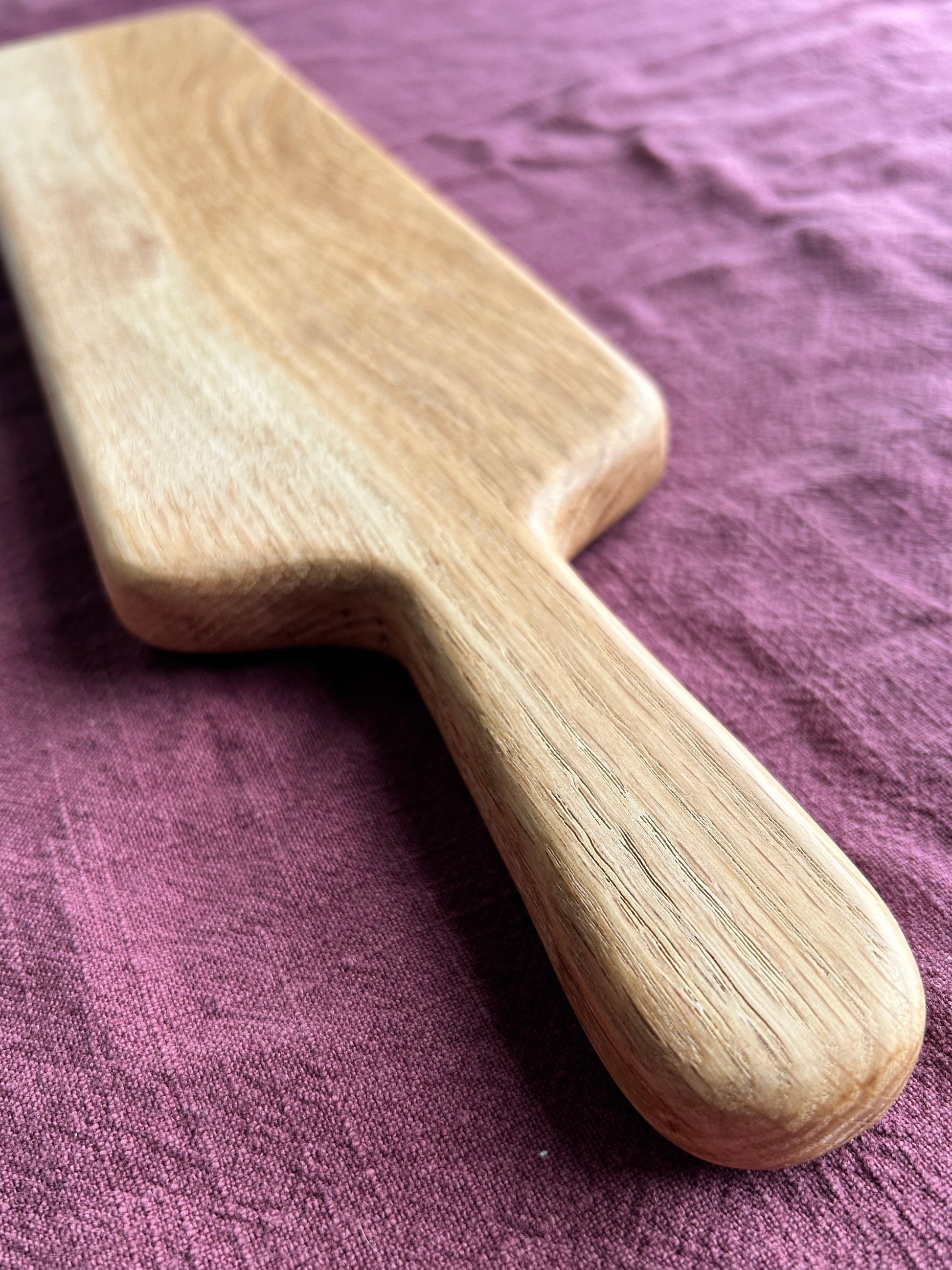 Wooden charcuterie board on a textured purple surface